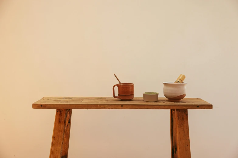 two mugs sitting on top of an old wooden table