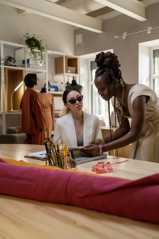 a woman helps another person work on soing