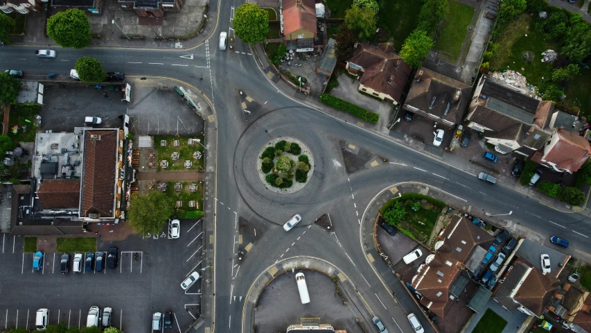 an aerial view of a city intersection with trees, buildings and cars