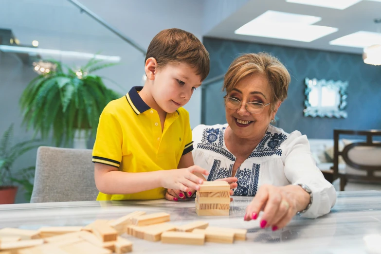 a woman and child playing with wood blocks