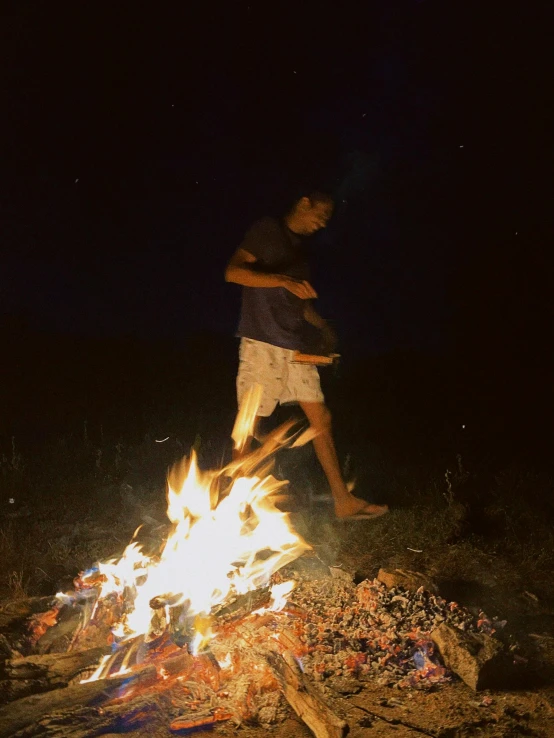 two men are running around a fire and looking at the flame