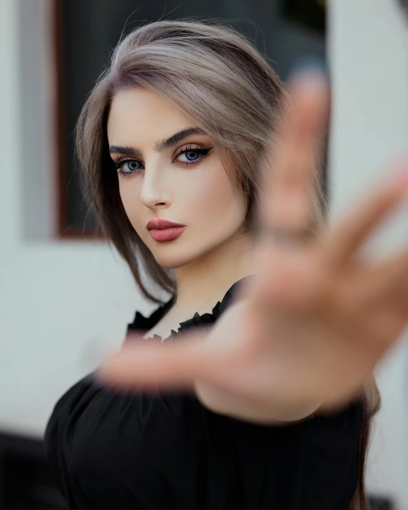 a young woman poses in a black top and poses for the camera