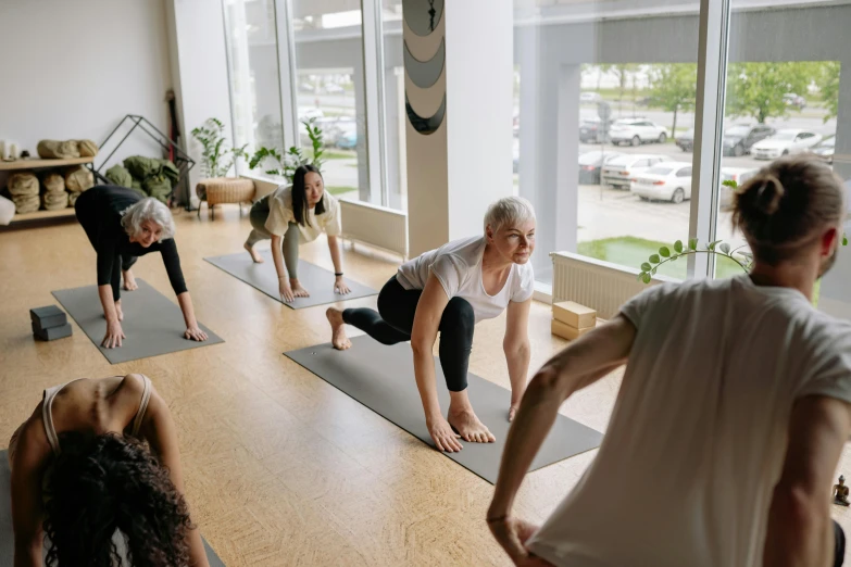 several people doing yoga exercises in front of a window