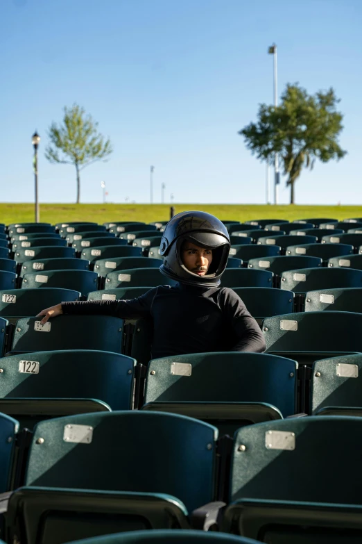 a little boy with a helmet and safety gear sitting in some seats