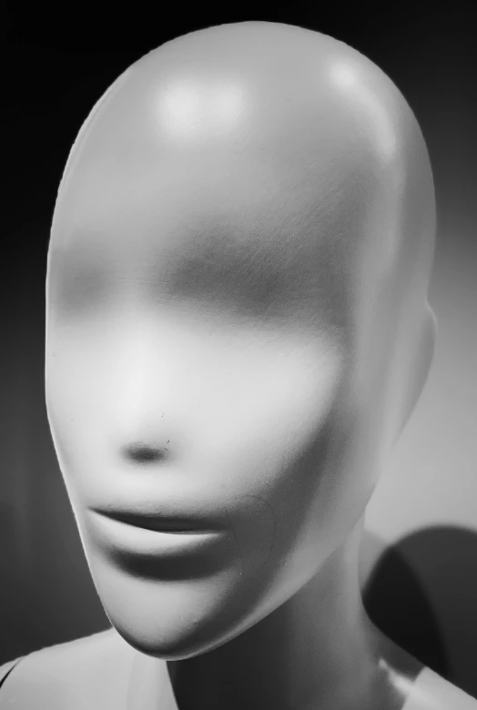 a mannequin's head with an open mouth in black and white