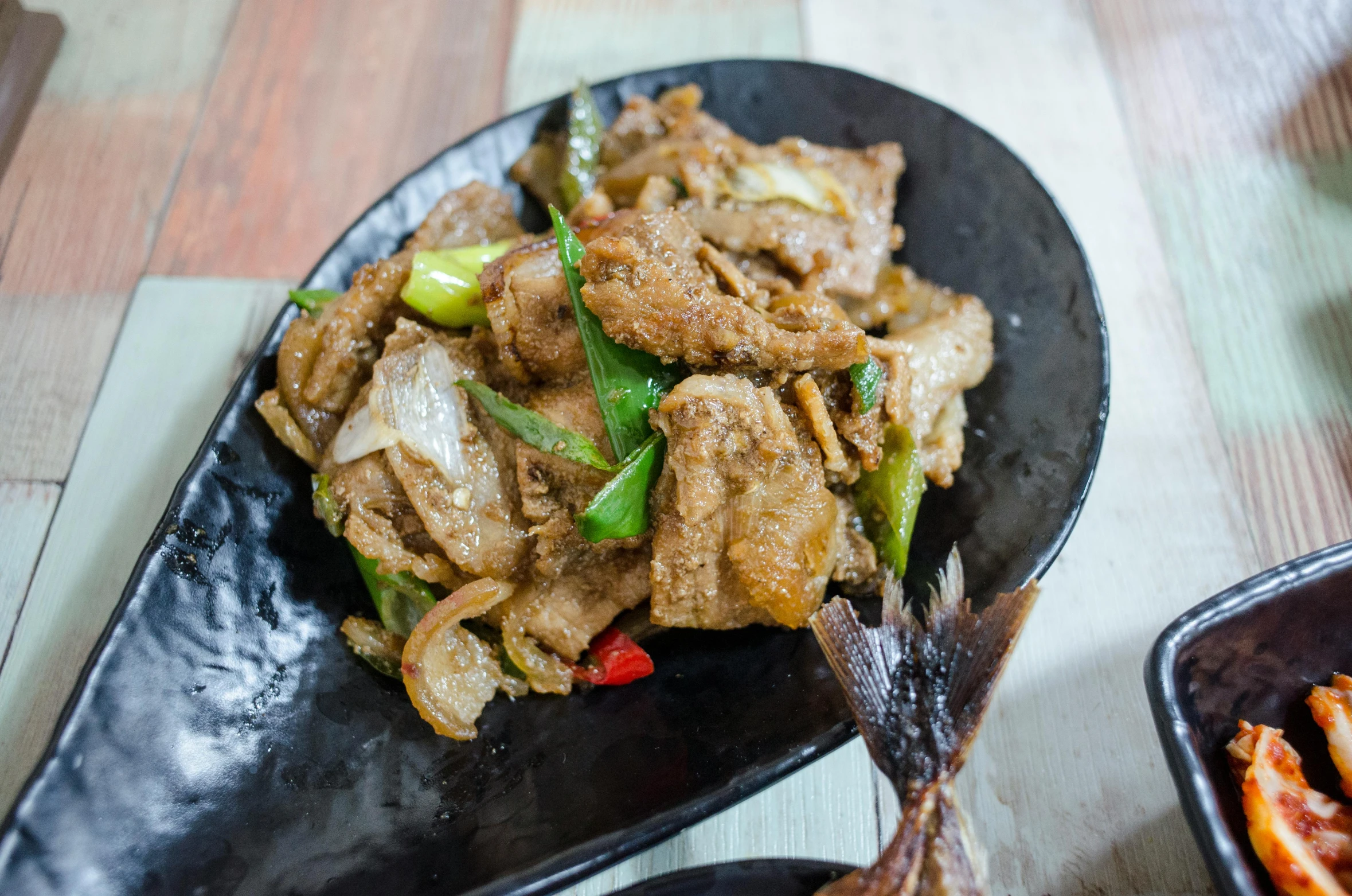 food being served on black serving platter with chop sticks