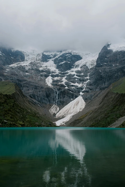 snowy mountain scenery with some water in front