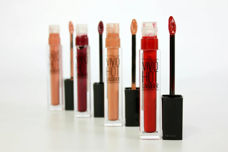 the five lip - glosses of various colors with lids