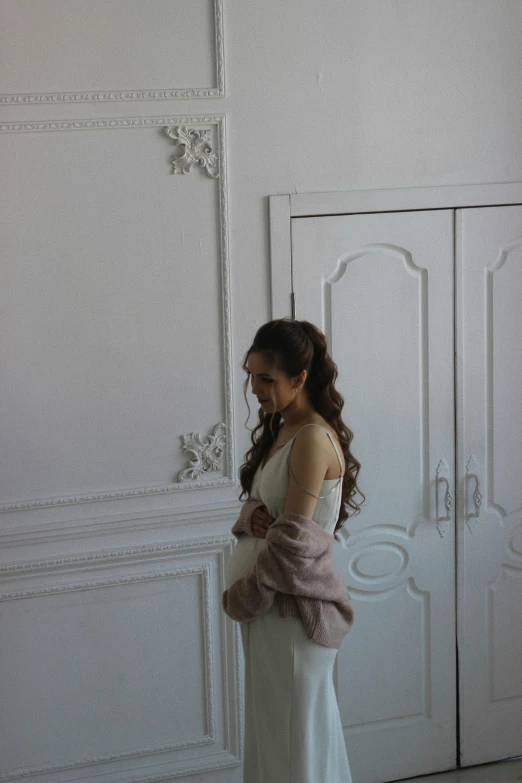 woman with white dress and brown jacket walking in room