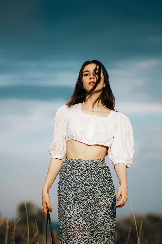 a woman is standing on the grassy plain and looking away