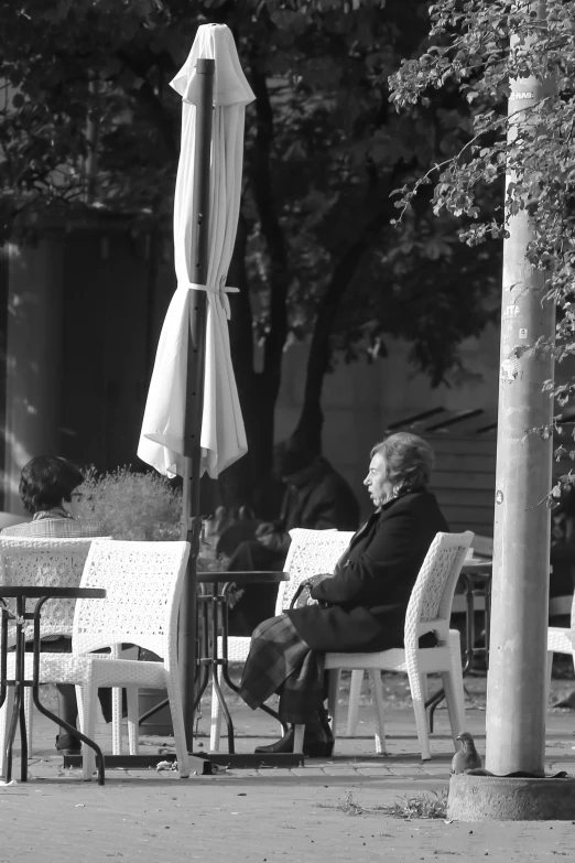 an older person sits on a bench outside of a restaurant