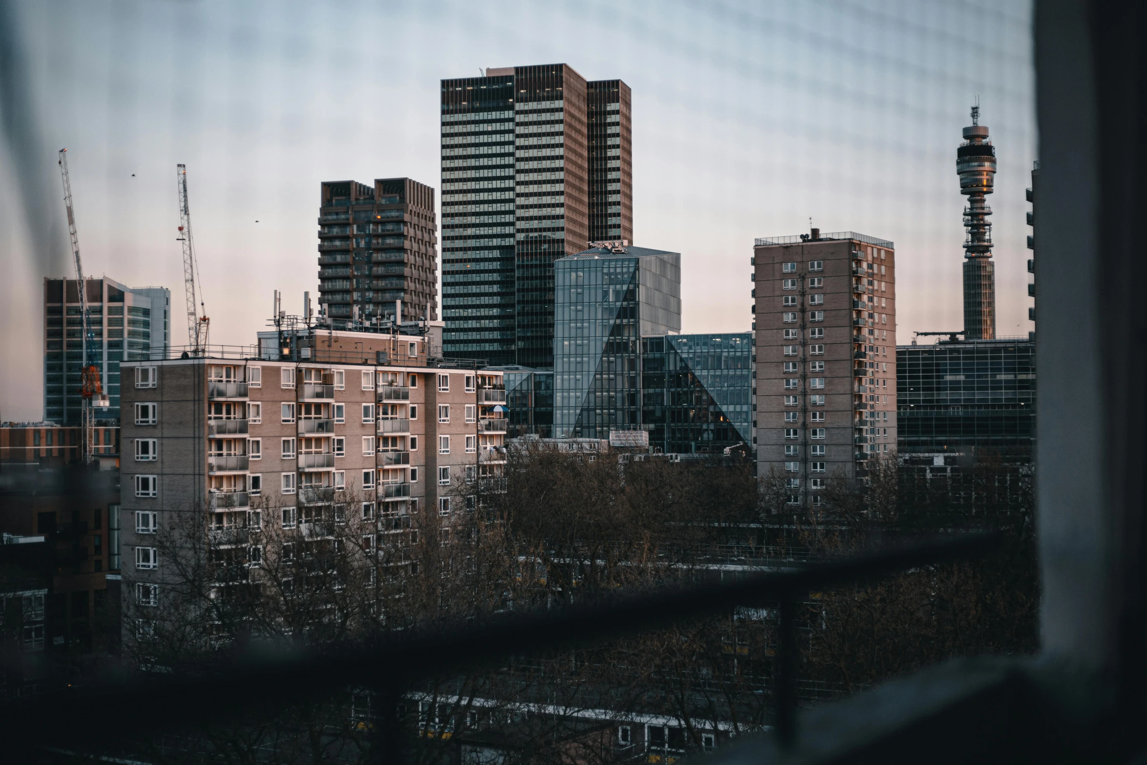 high rise buildings are seen in the distance from a window