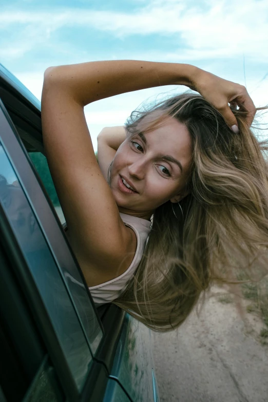 a woman leans out the window of a car