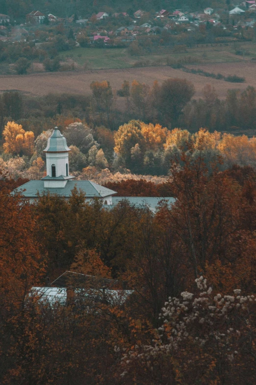 a building with a clock tower overlooks a lake and trees