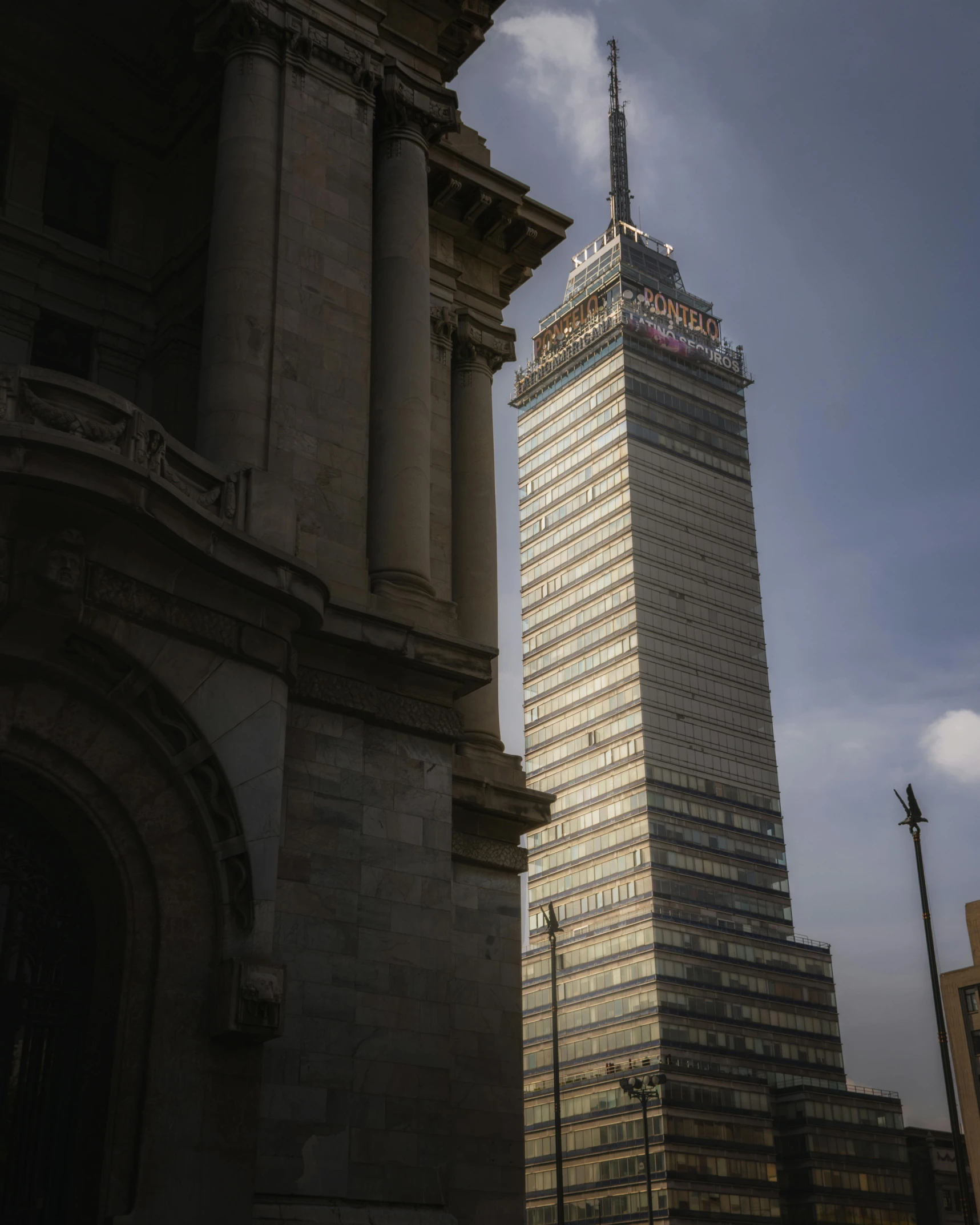 a tall tower with a sign on it next to a statue of two people