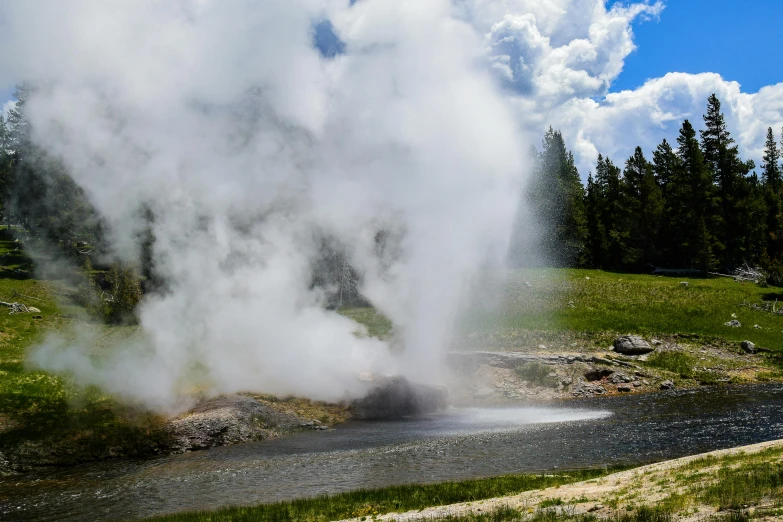 a very large cloud of smoke flying off the top of a rock