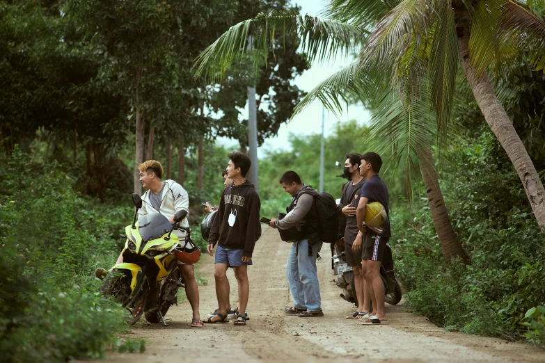 people are standing next to a motorcycle and looking at soing