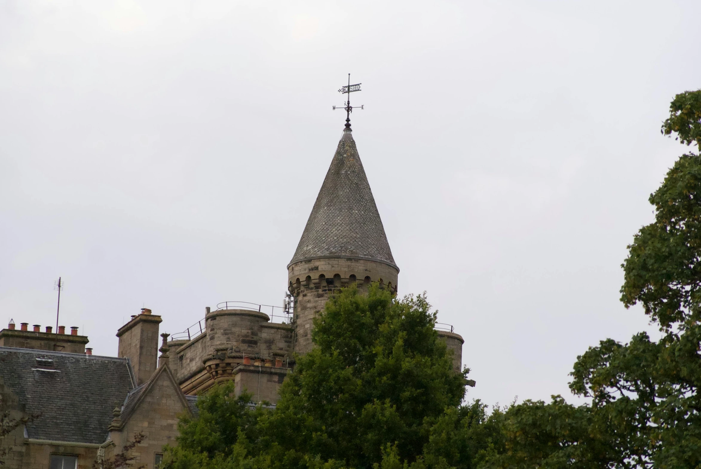 a building is shown with a tower and weather vane