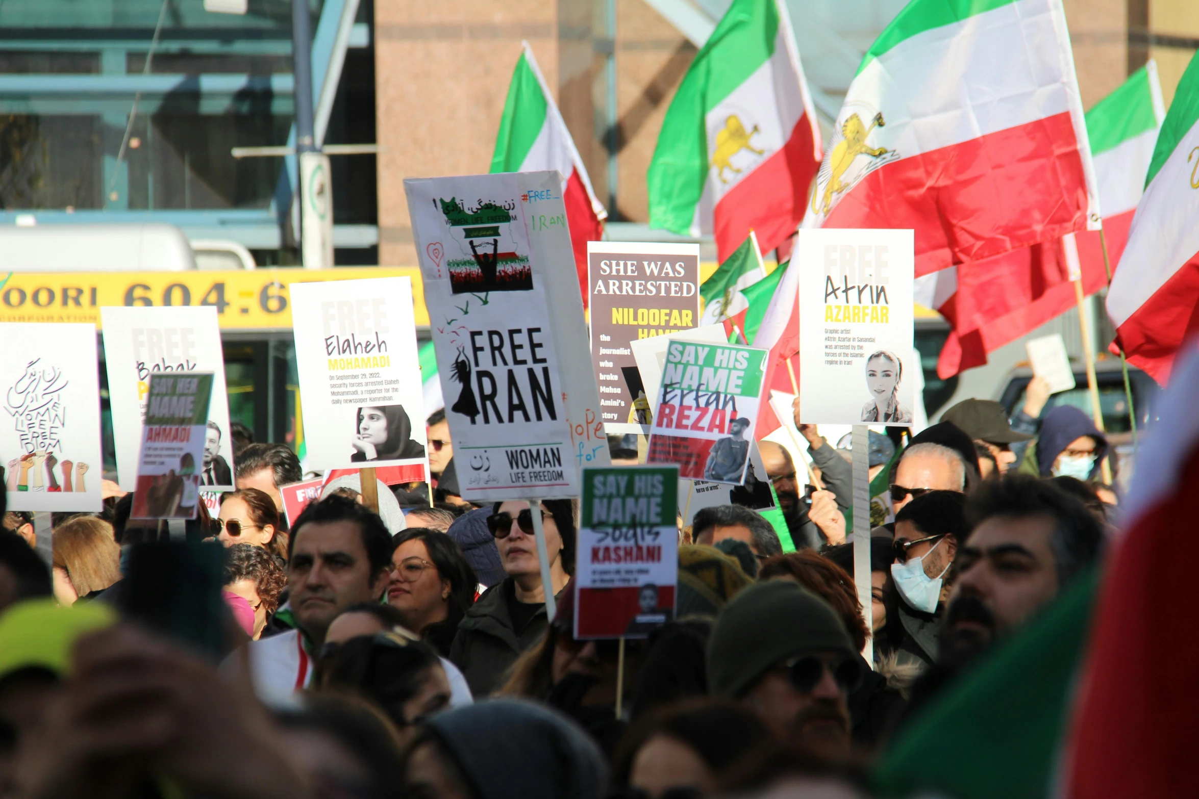 many people holding flags and signs in a protest