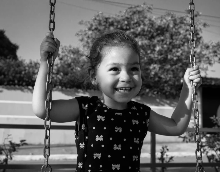 a girl smiles as she swings on a swing