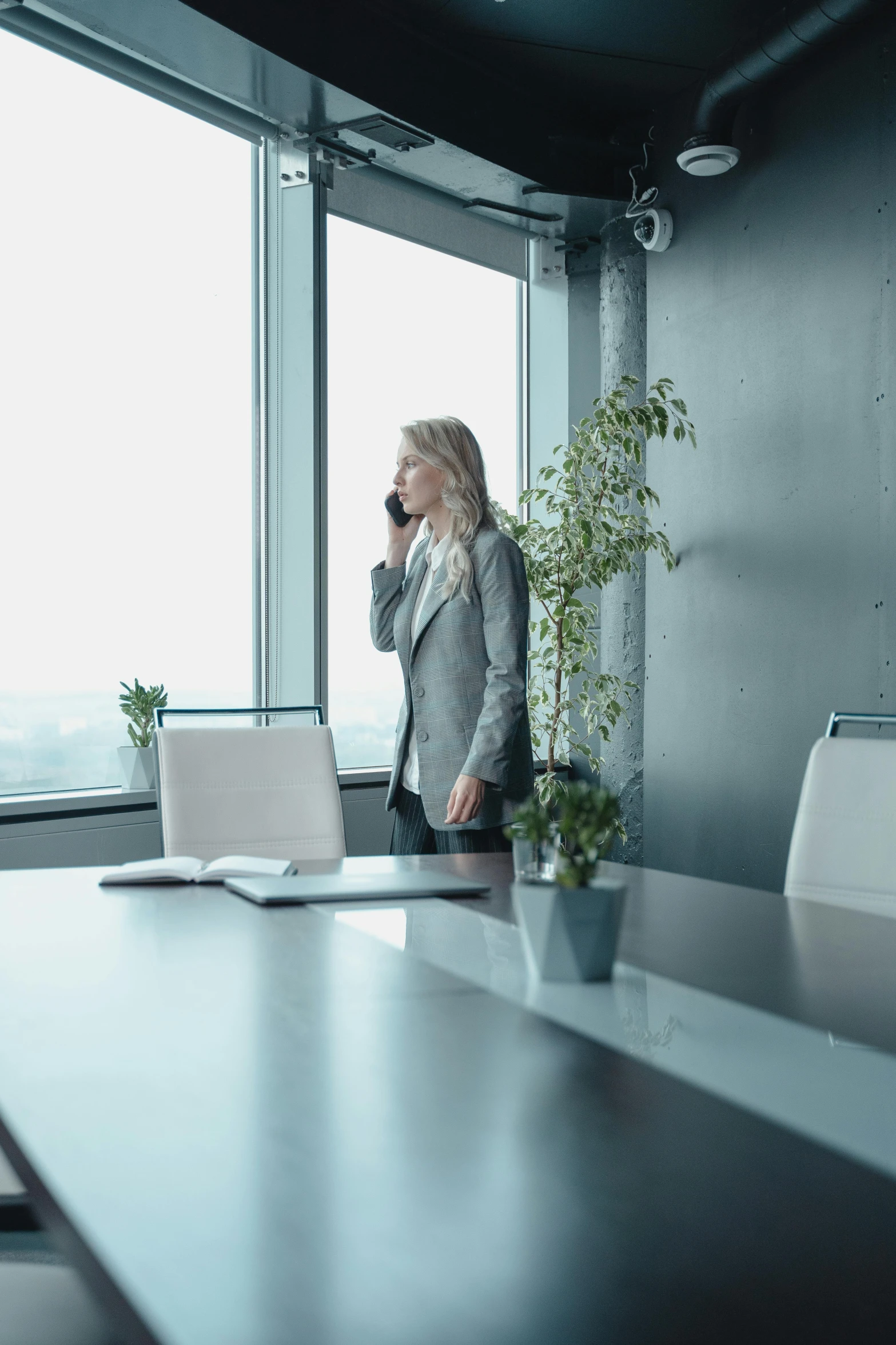 an office worker on her cell phone standing by the desk