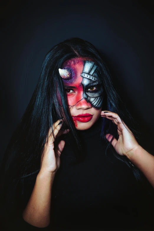 a person with black hair and makeup wearing a mask