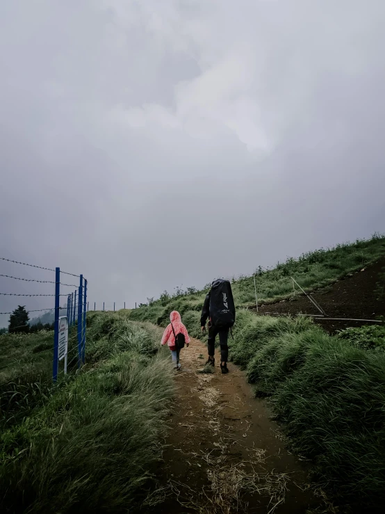 two people are walking down the path to their destination