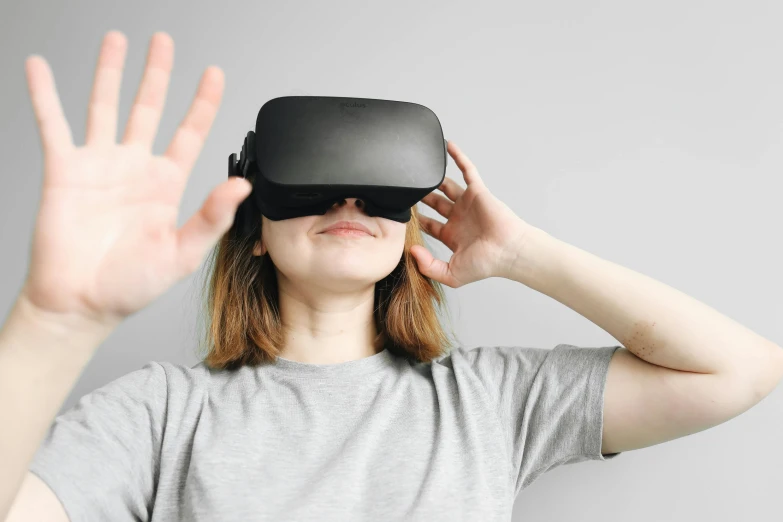 a girl wearing a virtual - blind holding her hands out