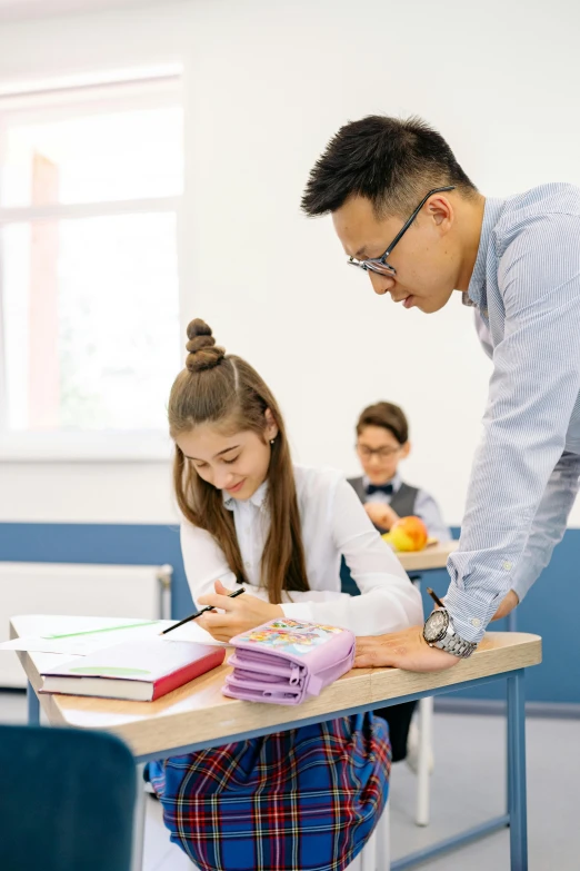 a man and a girl who are writing in school