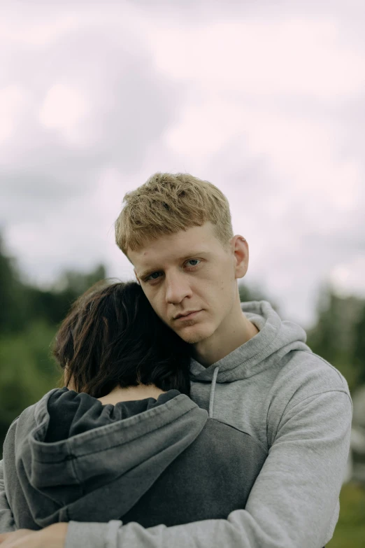 a couple emce each other while in the middle of an overcast sky