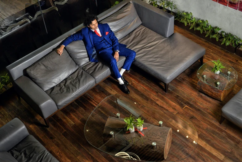 a man in a blue suit laying on a couch