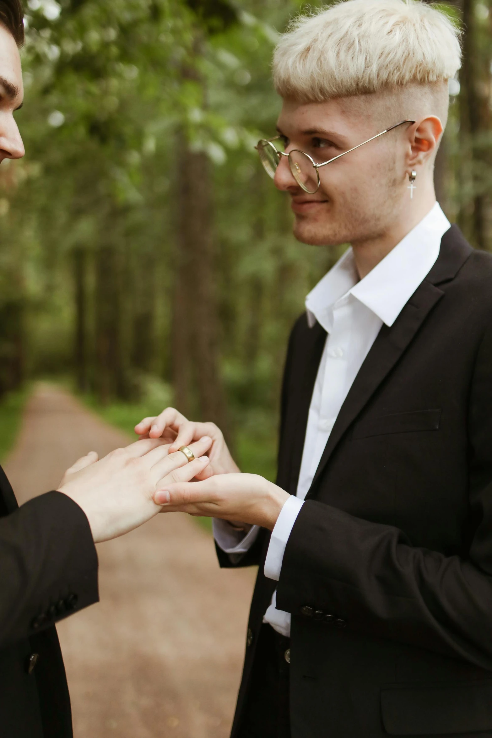 two young men in formal wear touching hands