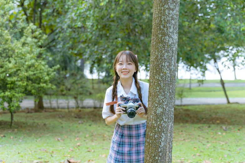  posing for pograph in front of a tree