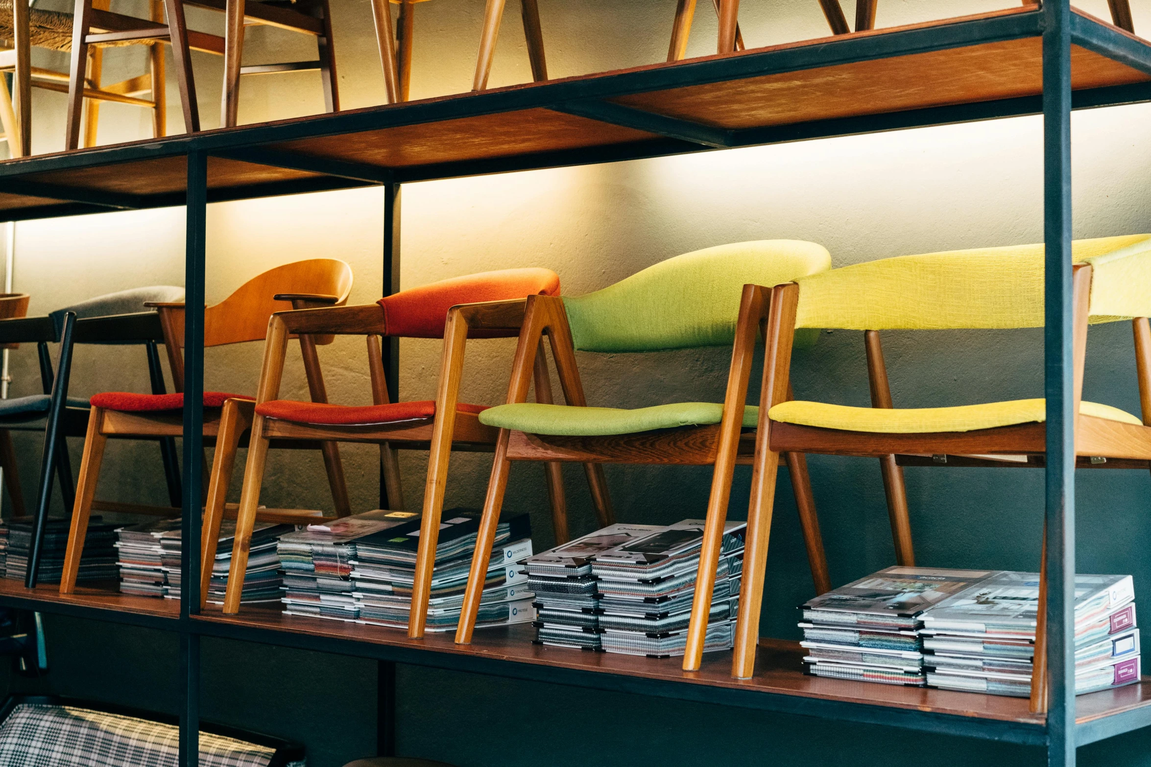 several colorful chairs sit next to each other near the bookcase