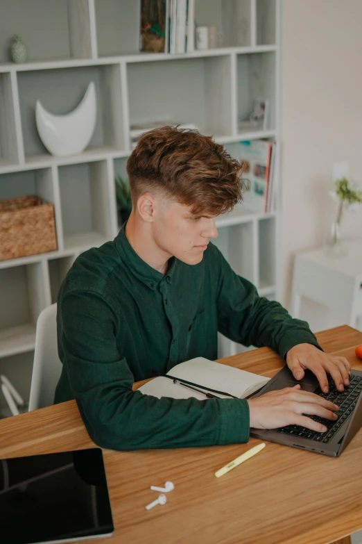 boy using his laptop while working on soing