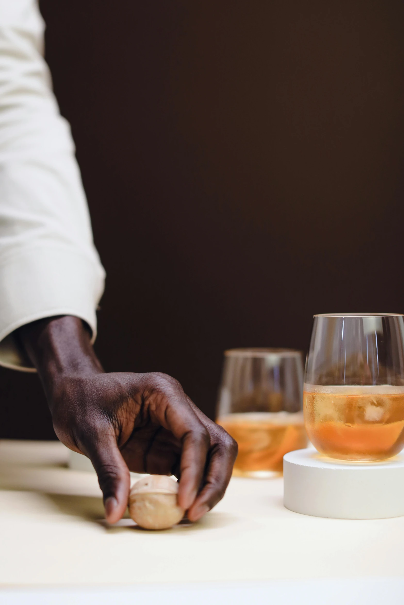 the man is holding a small piece of bread while having drinks