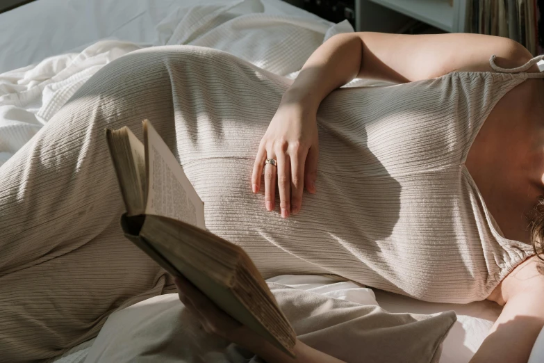 a beautiful young woman laying on top of a bed