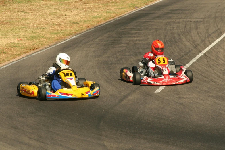 two go kart drivers racing down the track