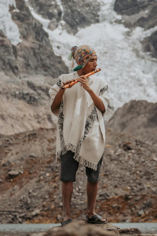 a woman with a stick stands in front of some snow covered mountains