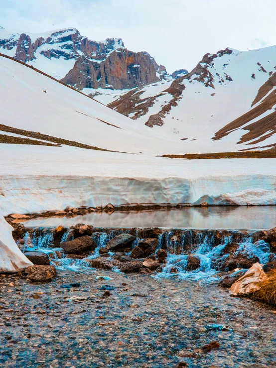 blue liquid and ice falling from mountains in snow