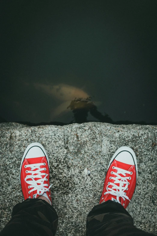 the feet of a man who is wearing red shoes