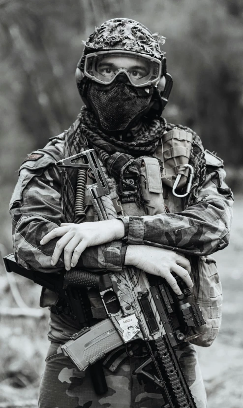 man in camouflage gear holding a machine gun