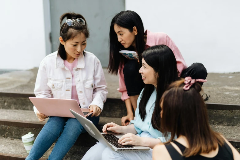 a group of people sitting on stairs with laptops