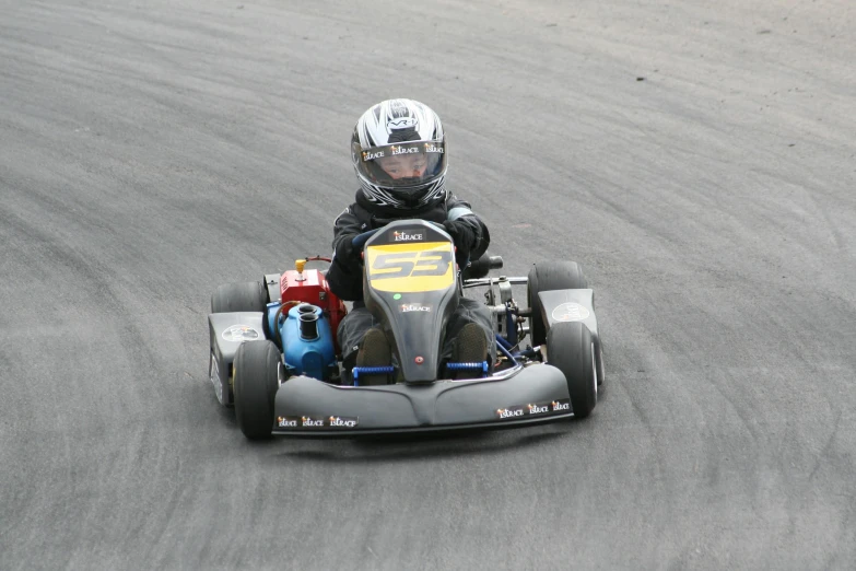 a small boy is racing on an go kart