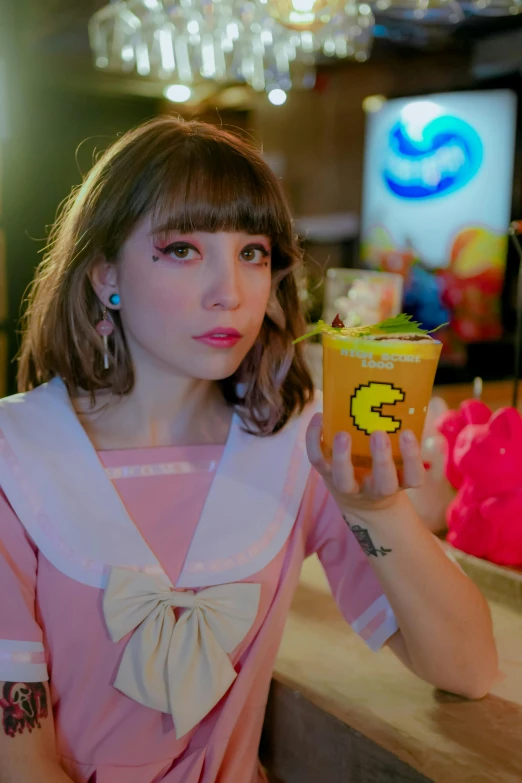 a woman in a pink dress holding a cup