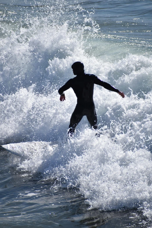 a person in a wet suit is on a surfboard in the waves