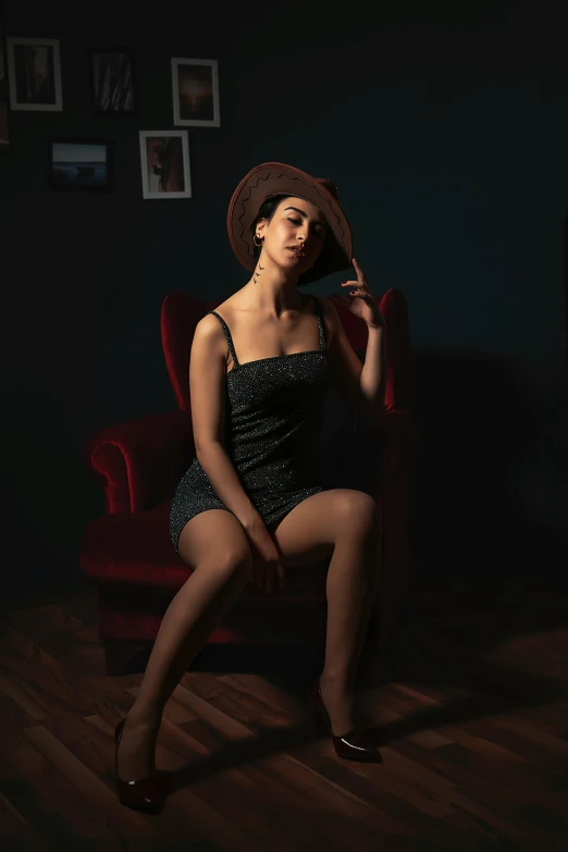 the woman is sitting down in a chair wearing a hat