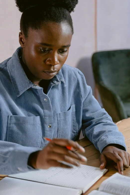 a woman is sitting at a table with an open book