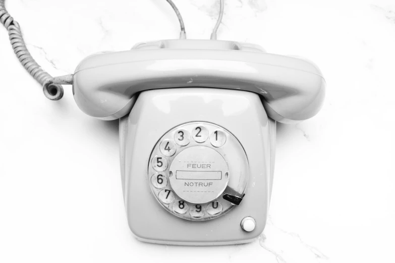 an old rotary phone on a marble surface