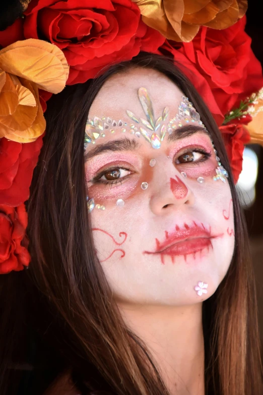 a woman with face art next to red roses